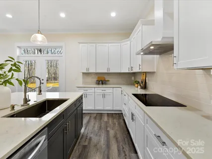 a kitchen with kitchen island granite countertop a sink a counter space appliances and cabinets