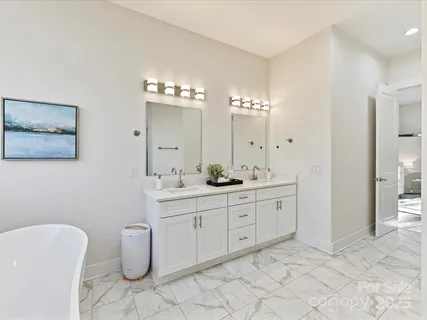 a spacious bathroom with a double vanity sink mirror and bathtub