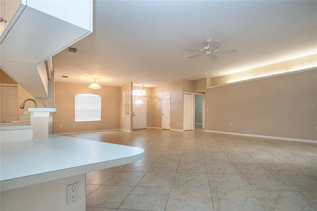 a view of an empty room with a kitchen