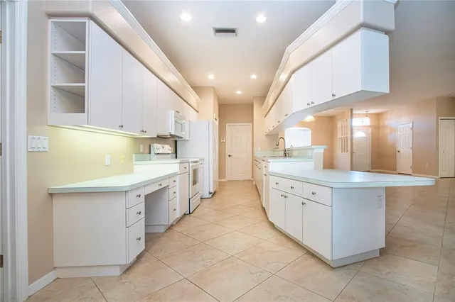 a large kitchen with stainless steel appliances lots of counter space and windows