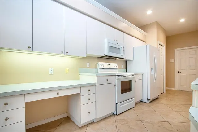 a kitchen with white cabinets and white appliances