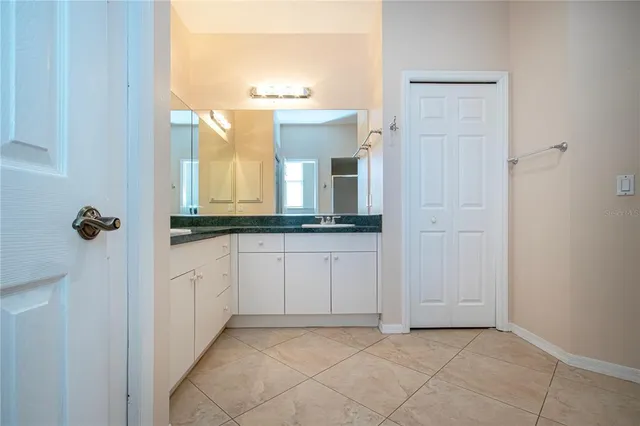 a bathroom with a granite countertop sink and a mirror