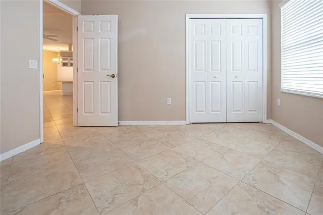 an empty room with windows and cabinet
