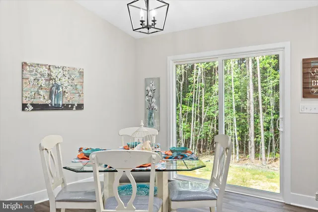 a view of a dining room with furniture a chandelier and wooden floor