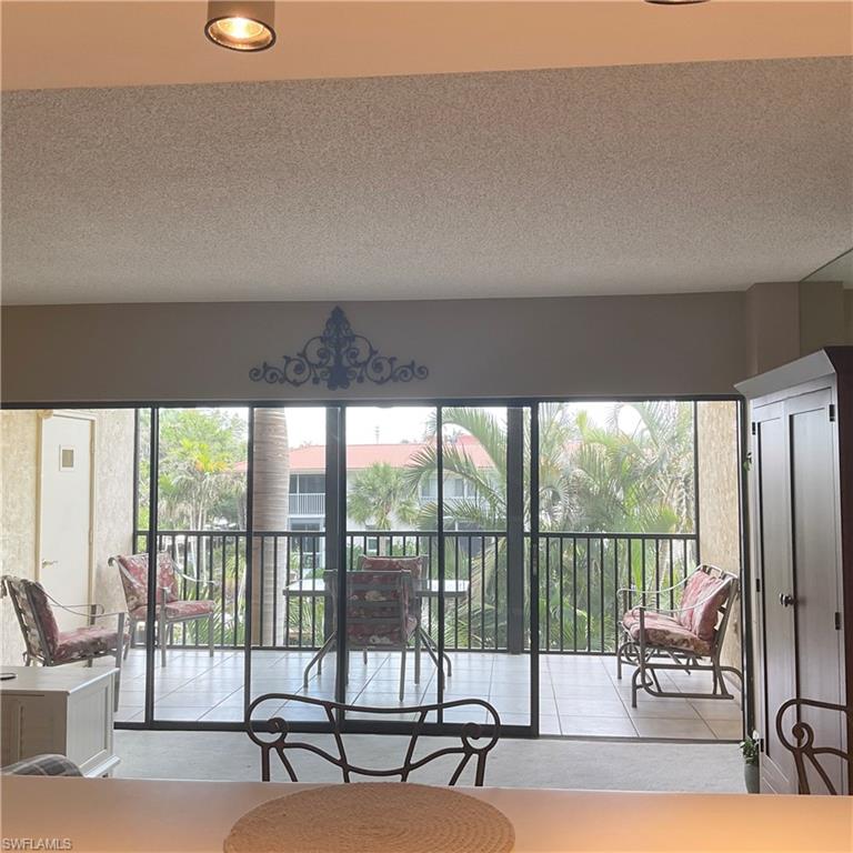 1165 Clam Court, Unit 7 Naples, FL 34102 - Photo 13 of 34 a living room with furniture and a floor to ceiling window
