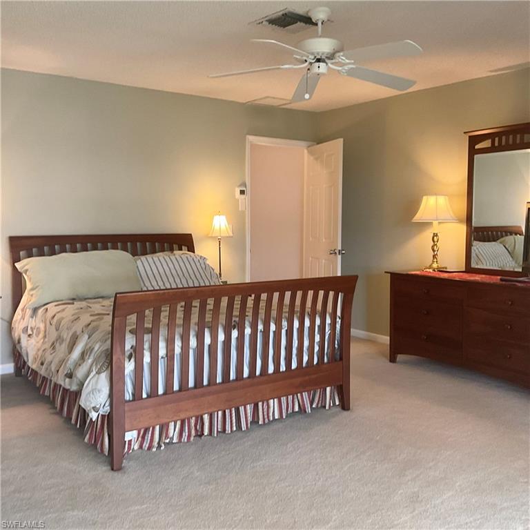 1165 Clam Court, Unit 7 Naples, FL 34102 - Photo 16 of 34 a bed sitting in a bedroom next to a lamp