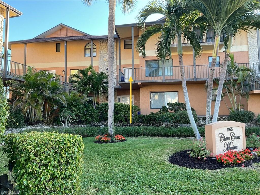 1165 Clam Court, Unit 7 Naples, FL 34102 - Photo 2 of 34 a front view of a house with a yard and potted plants