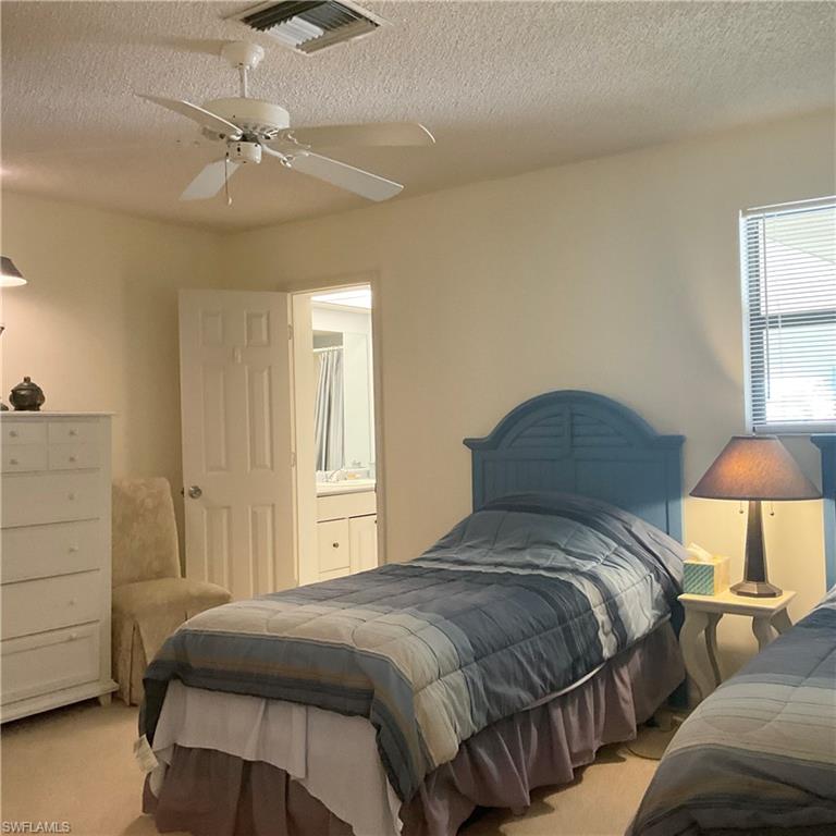 1165 Clam Court, Unit 7 Naples, FL 34102 - Photo 24 of 34 a bedroom with a bed and a lamp