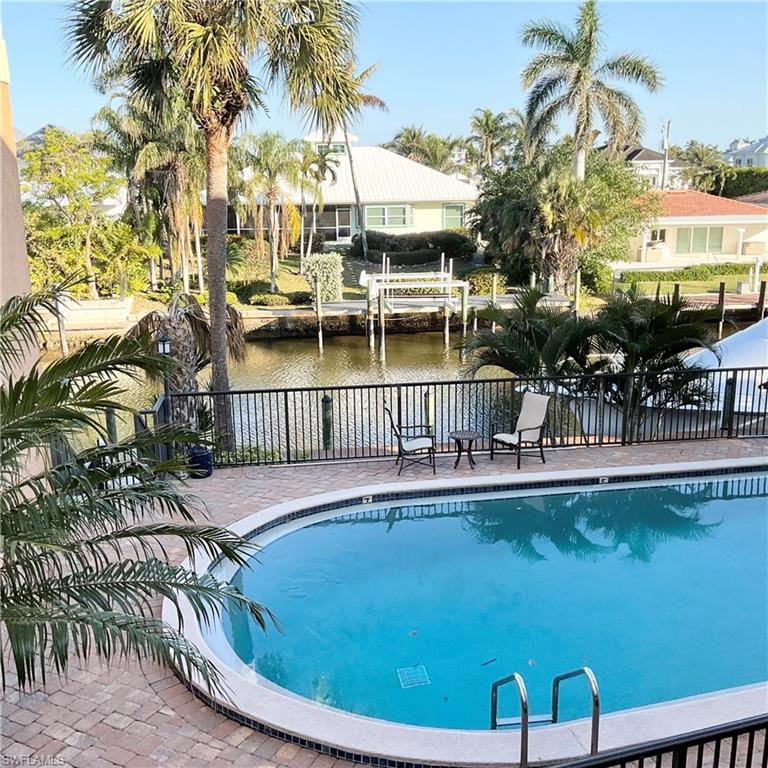 1165 Clam Court, Unit 7 Naples, FL 34102 - Photo 29 of 34 a view of a swimming pool with a table and chairs