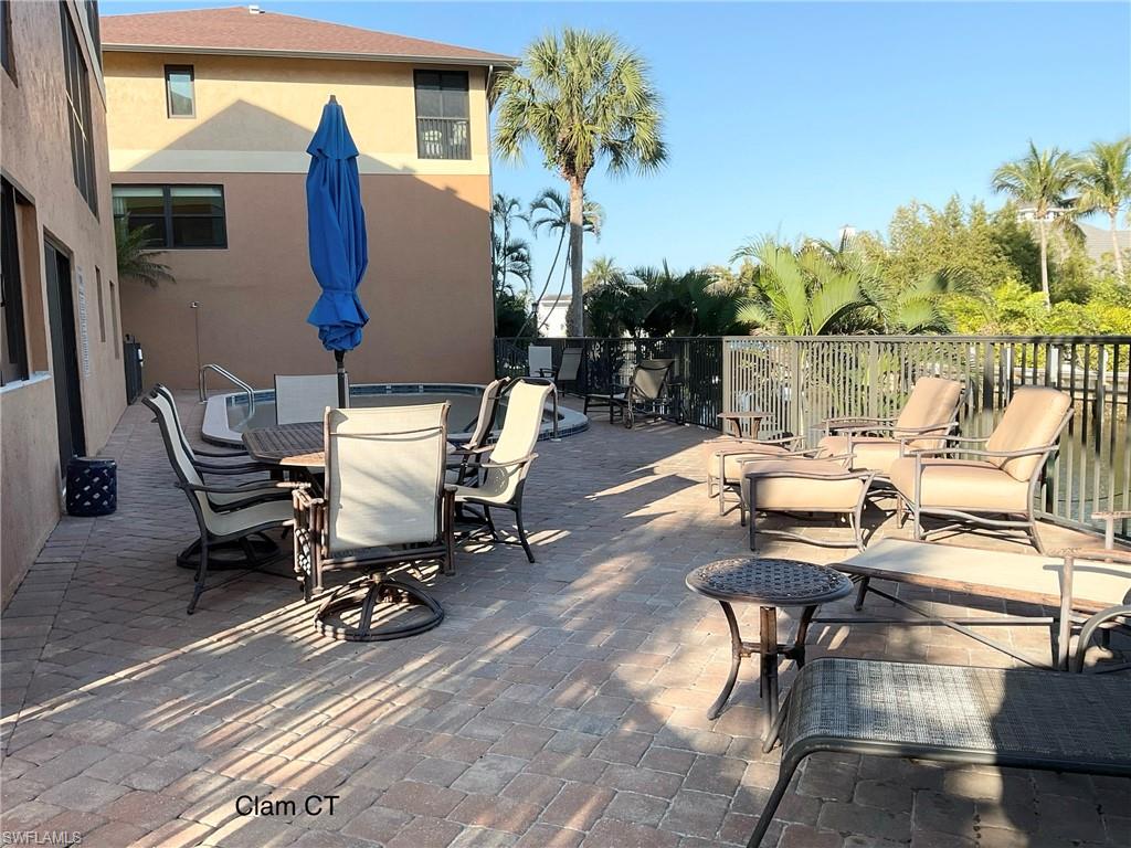 1165 Clam Court, Unit 7 Naples, FL 34102 - Photo 31 of 34 a view of a patio with a table and chairs