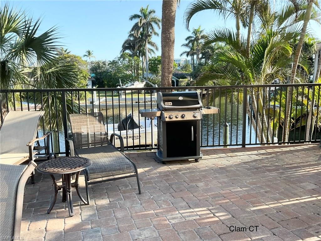 1165 Clam Court, Unit 7 Naples, FL 34102 - Photo 32 of 34 a view of a dinning table and chairs in patio