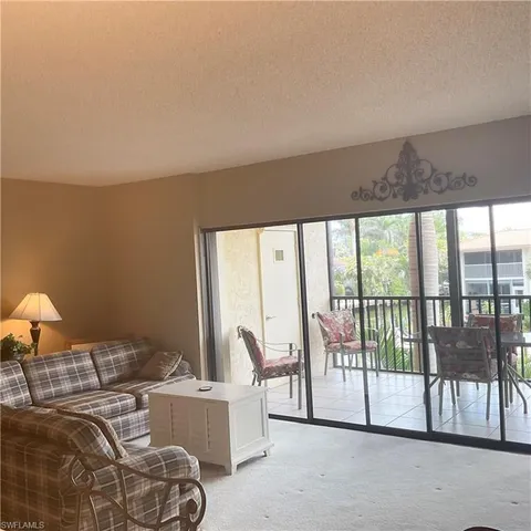 a living room with furniture and large windows