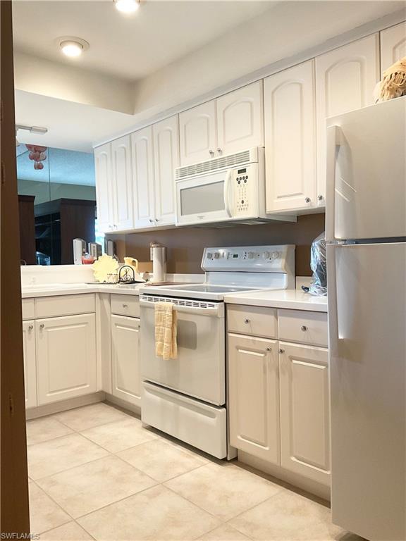 1165 Clam Court, Unit 7 Naples, FL 34102 - Photo 10 of 34 a kitchen with white cabinets sink and white appliances
