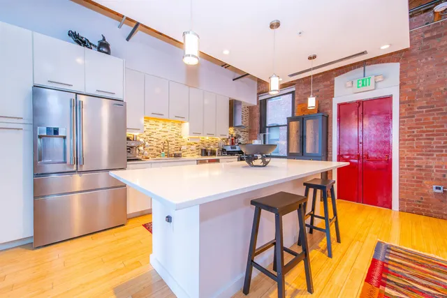 a kitchen with stainless steel appliances granite countertop a sink a stove and a refrigerator