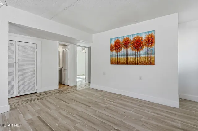 a kitchen with granite countertop white cabinets and a white wooden floor