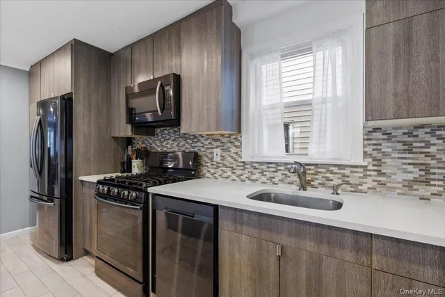 a kitchen with stainless steel appliances a dining table chairs and a refrigerator