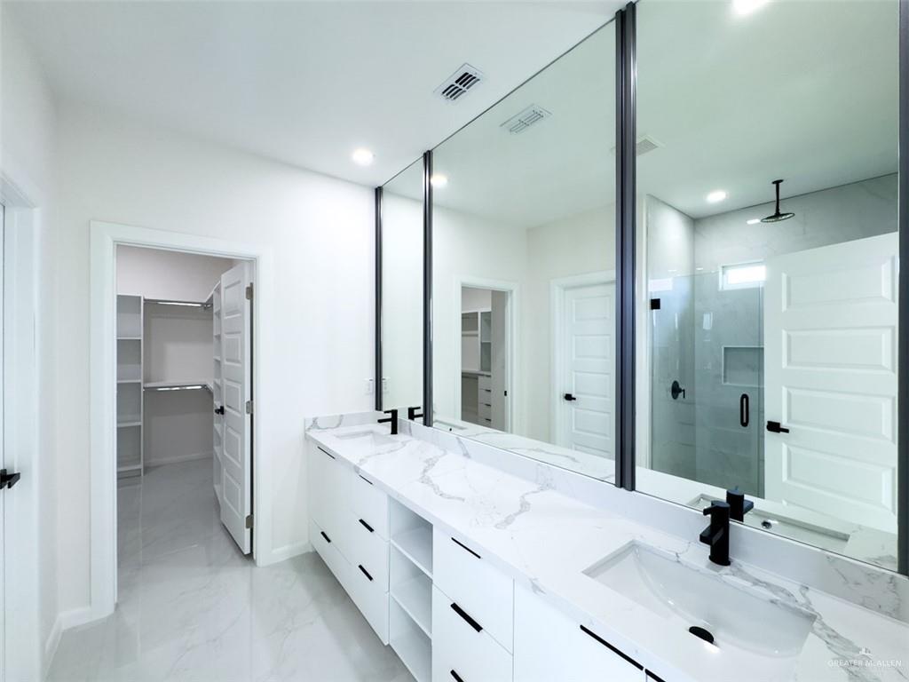 4812 Duke Avenue McAllen, TX 78504 - Photo 25 of 42 a bathroom with a double vanity sink mirror and shower
