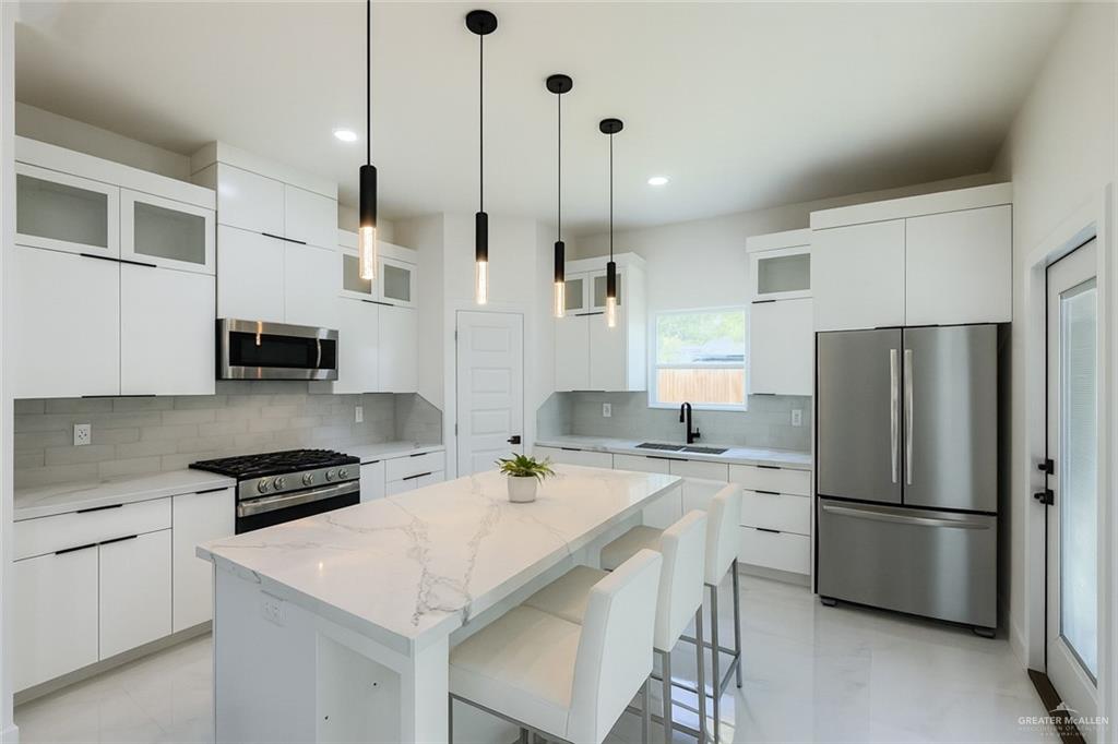 4812 Duke Avenue McAllen, TX 78504 - Photo 5 of 42 a kitchen with stainless steel appliances a stove a sink a refrigerator a center island a stove and a refrigerator