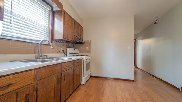 a kitchen with a sink cabinets stainless steel appliances and a window