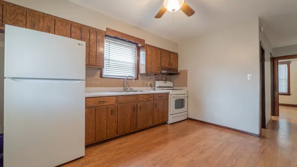 a kitchen with a refrigerator a sink and dishwasher with wooden floor