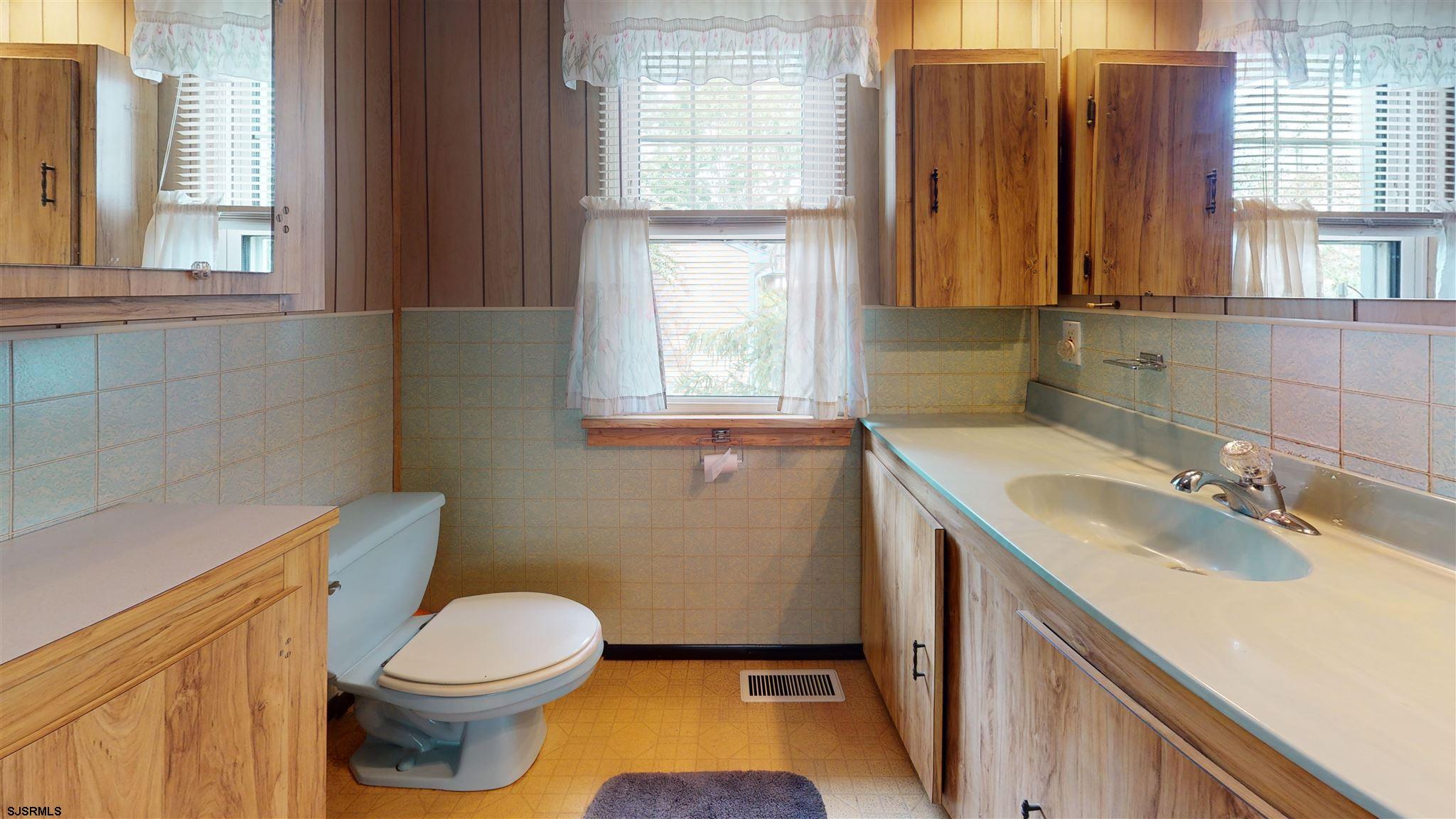 613 3rd Street Somers Point, NJ 08244 - Photo 15 of 22 a bathroom with a granite countertop toilet a sink and a window