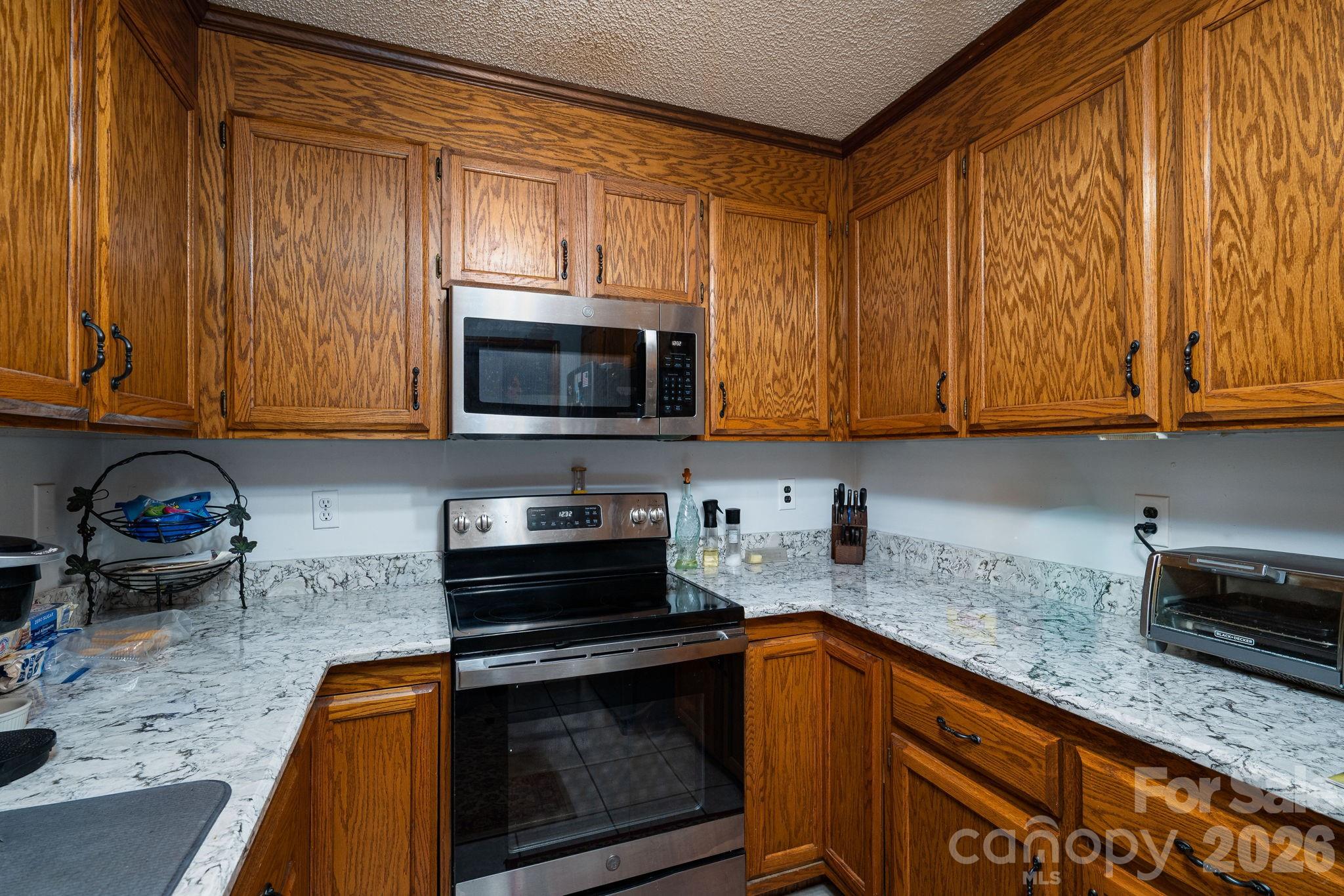 3815 Wildcherry Road Shelby, NC 28150 - Photo 13 of 33 a kitchen with stainless steel appliances granite countertop a sink stove and microwave