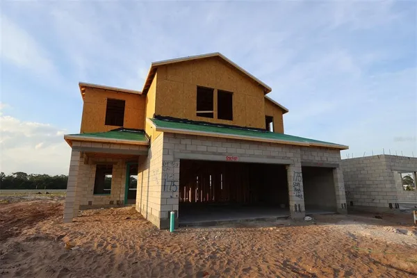 a front view of a house with yard and parking