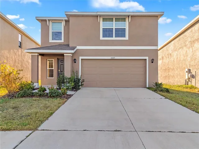 a front view of a house with a yard and garage