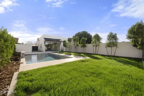 a view of a house with swimming pool and a yard