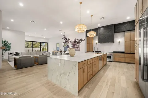 a large white kitchen with a large counter top and stainless steel appliances