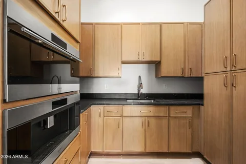 a kitchen with granite countertop white cabinets and stainless steel appliances