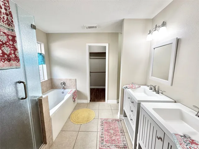 a bathroom with a tub sink and mirror