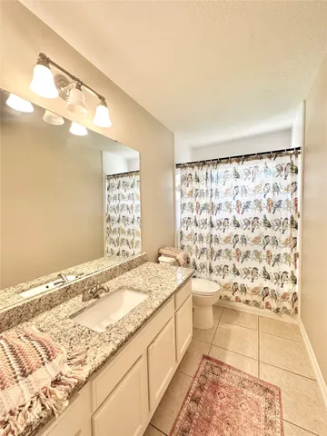 a bathroom with a granite countertop sink and a bathtub