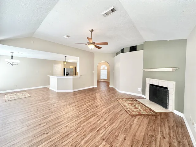 a view of empty room with wooden floor and fireplace
