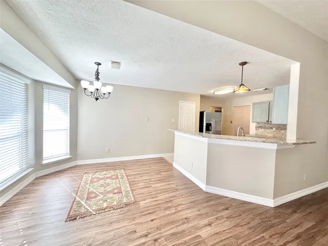 a view of a kitchen with wooden floor and a sink