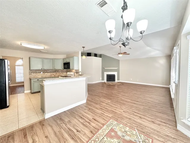 a view of kitchen with granite countertop cabinets and refrigerator