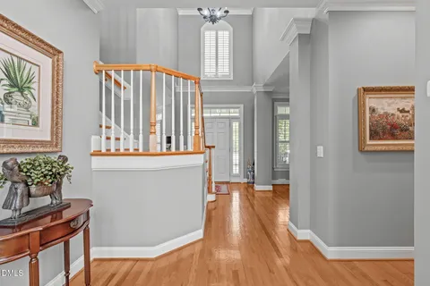 a view of a dining room with furniture a chandelier and wooden floor