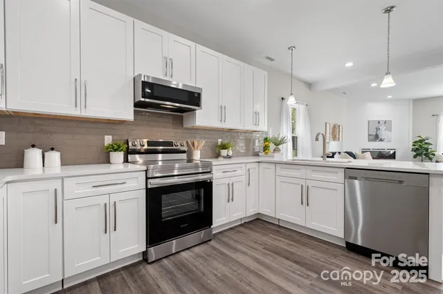 a kitchen with white cabinets stainless steel appliances and sink