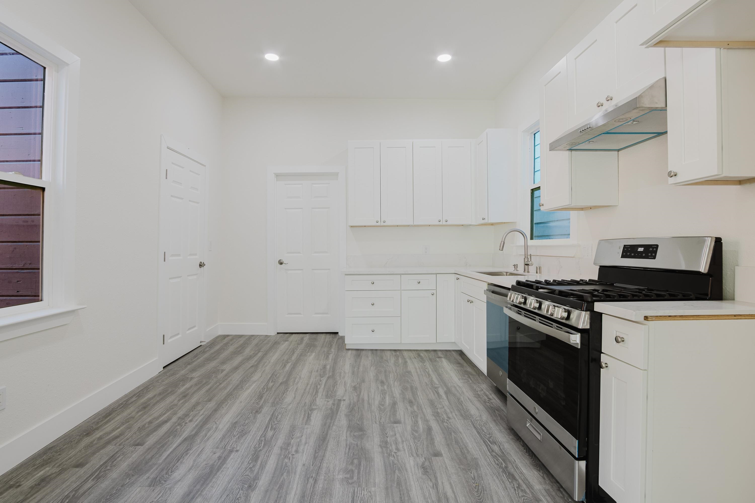 1778 8th Street Oakland, CA 94607 - Photo 6 of 35 a kitchen with granite countertop a stove and a sink