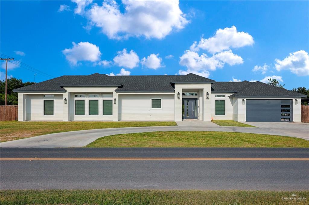 5284 North Mayberry Road Palmhurst, TX 78573 - Photo 1 of 26 a front view of a house with a yard and garage