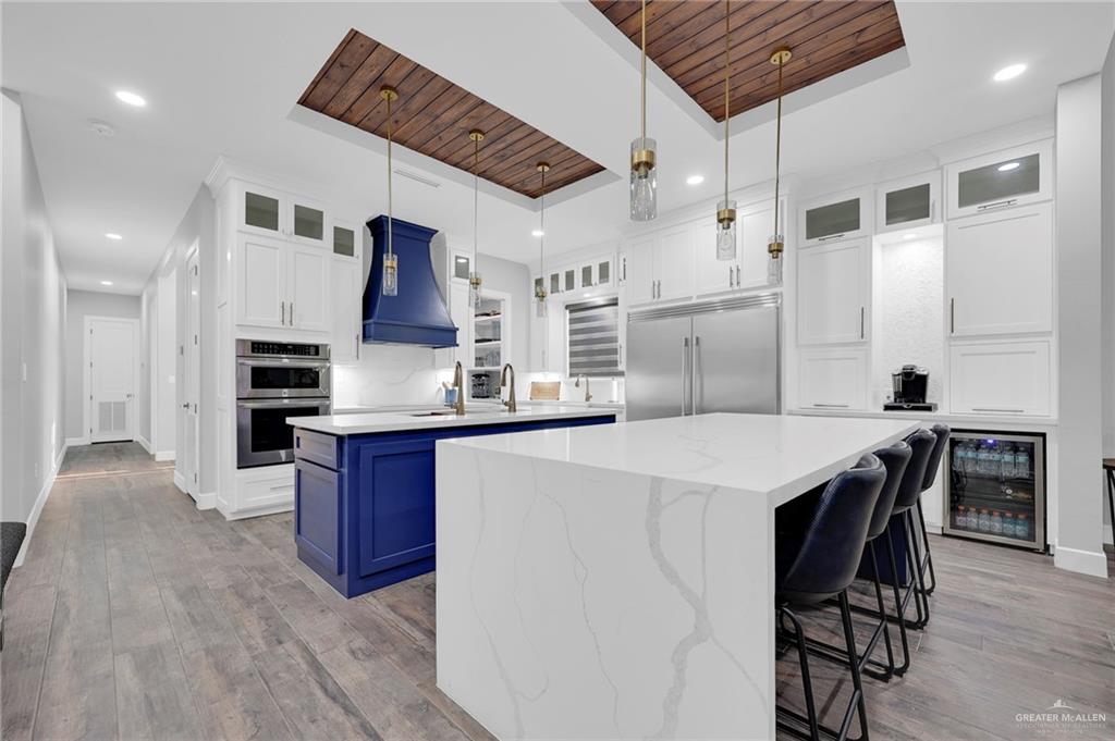 5284 North Mayberry Road Palmhurst, TX 78573 - Photo 2 of 26 a kitchen with stainless steel appliances kitchen island granite countertop a table chairs in it and wooden floors