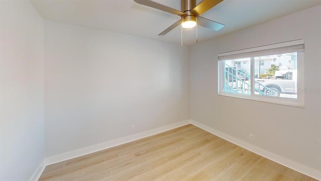 500 129th Avenue East, Unit 2 Madeira Beach, FL 33708 - Photo 11 of 16 an empty room with a window and wooden floor