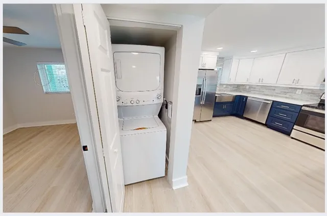 an empty room with wooden floor ceiling fan and windows