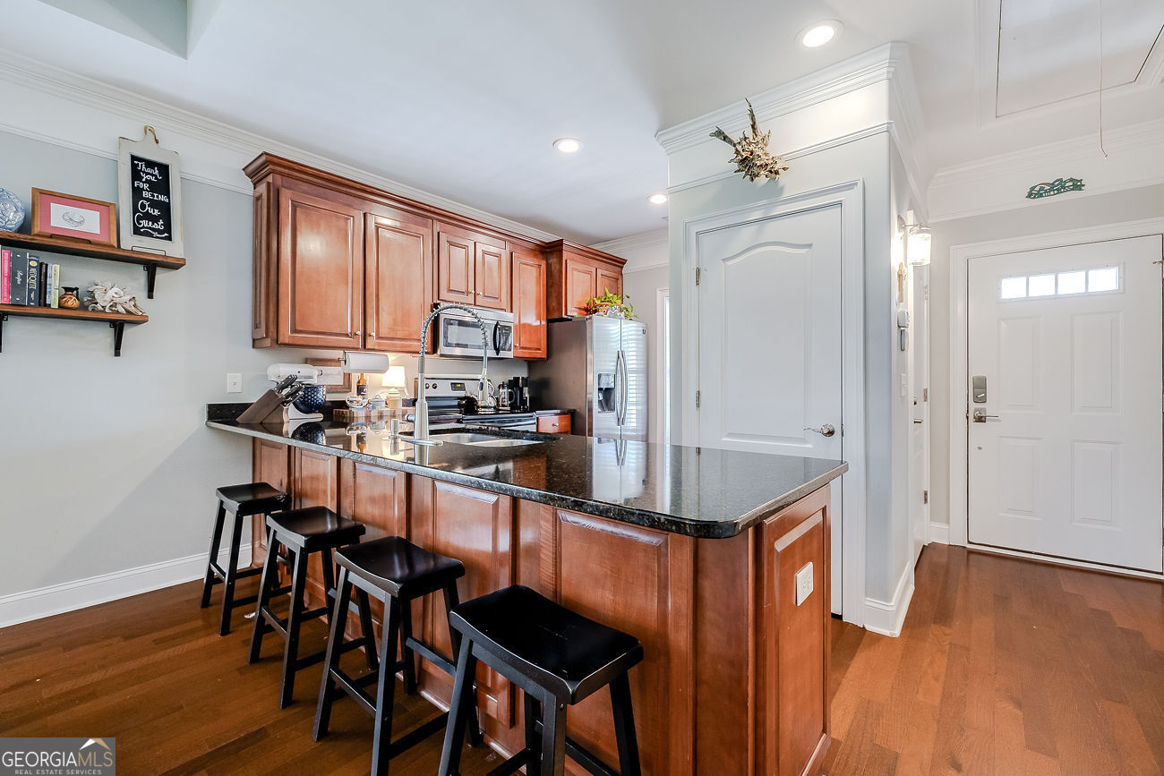 7272 Shellman Bluff Road Northeast, Unit 18 Townsend, GA 31331 - Photo 11 of 31 a room with stainless steel appliances kitchen island granite countertop furniture and a refrigerator