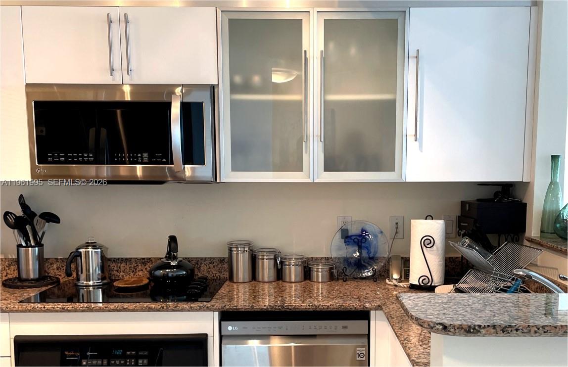 335 South Biscayne Boulevard, Unit 2212 Miami, FL 33131 - Photo 21 of 69 a kitchen with a microwave a stove and cabinets