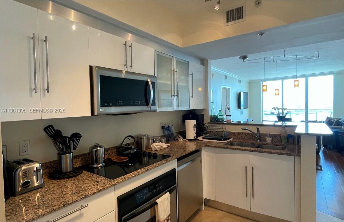 335 South Biscayne Boulevard, Unit 2212 Miami, FL 33131 - Photo 22 of 69 a kitchen with sink a microwave and cabinets