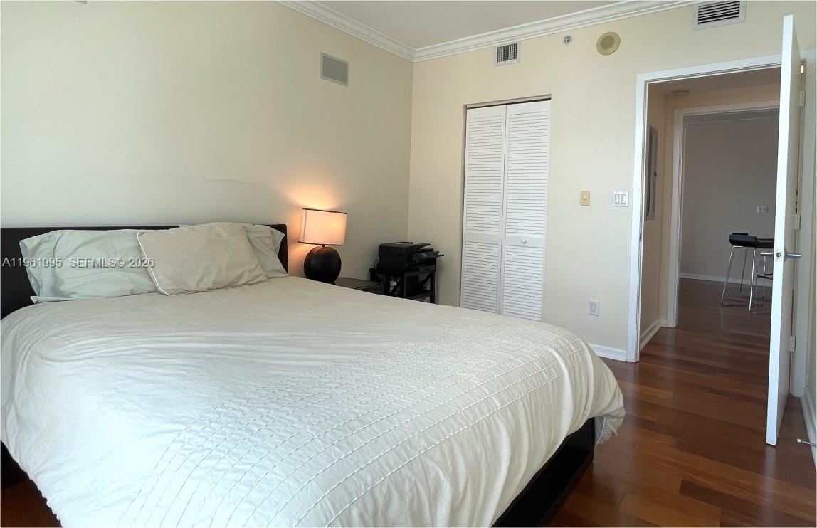 335 South Biscayne Boulevard, Unit 2212 Miami, FL 33131 - Photo 27 of 69 a bedroom with a bed and wooden floor