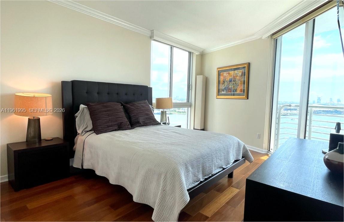 335 South Biscayne Boulevard, Unit 2212 Miami, FL 33131 - Photo 33 of 69 a bedroom with a bed and wooden floor