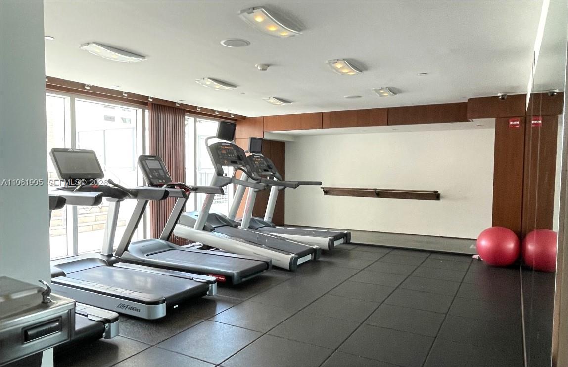 335 South Biscayne Boulevard, Unit 2212 Miami, FL 33131 - Photo 65 of 69 a room with gym equipment and a large window