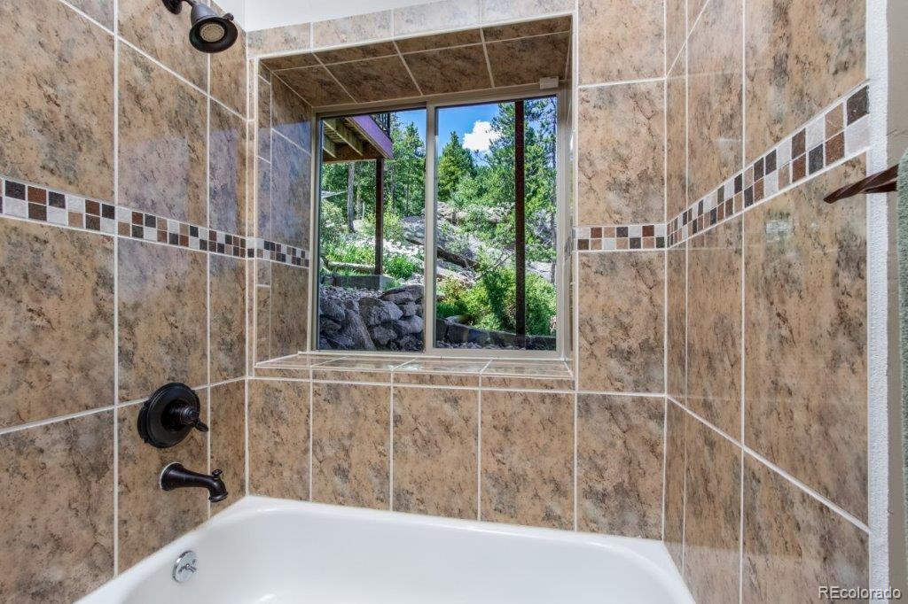 8044 Rossman Gulch Road Morrison, CO 80465 - Photo 11 of 34 a bathroom with a shower and a bathtub
